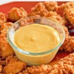 bowl of homemade Chick Fil A sauce and chicken nuggets on a platter.