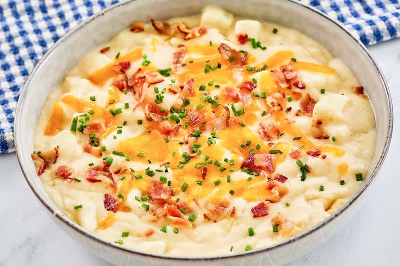 a bowl of copycat Chili's baked potato soup topped with bacon, cheese, and chives.