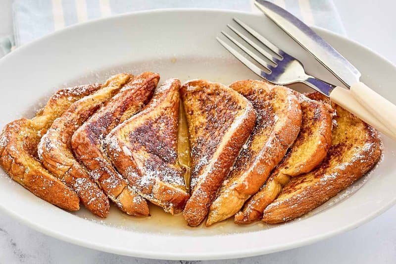 slices of copycat IHOP French Toast with syrup on a large plate.