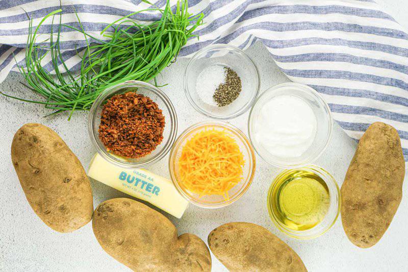 loaded twice baked potatoes ingredients and a kitchen towel.