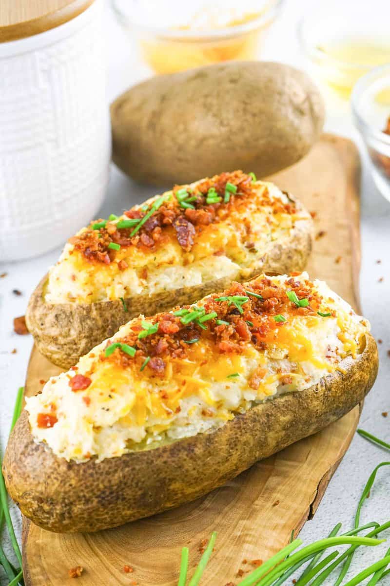 two loaded twice baked potatoes and one russet potato.
