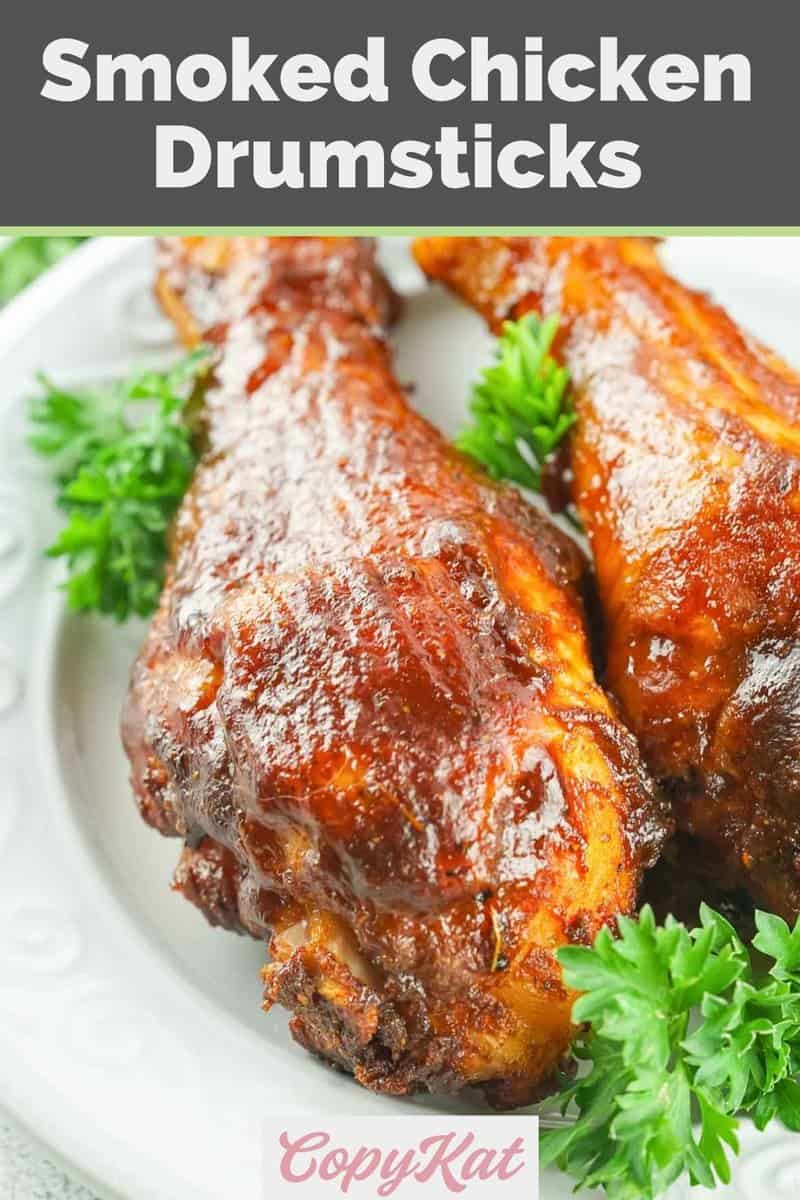 smoked barbecue chicken drumsticks and parsley on a white plate.