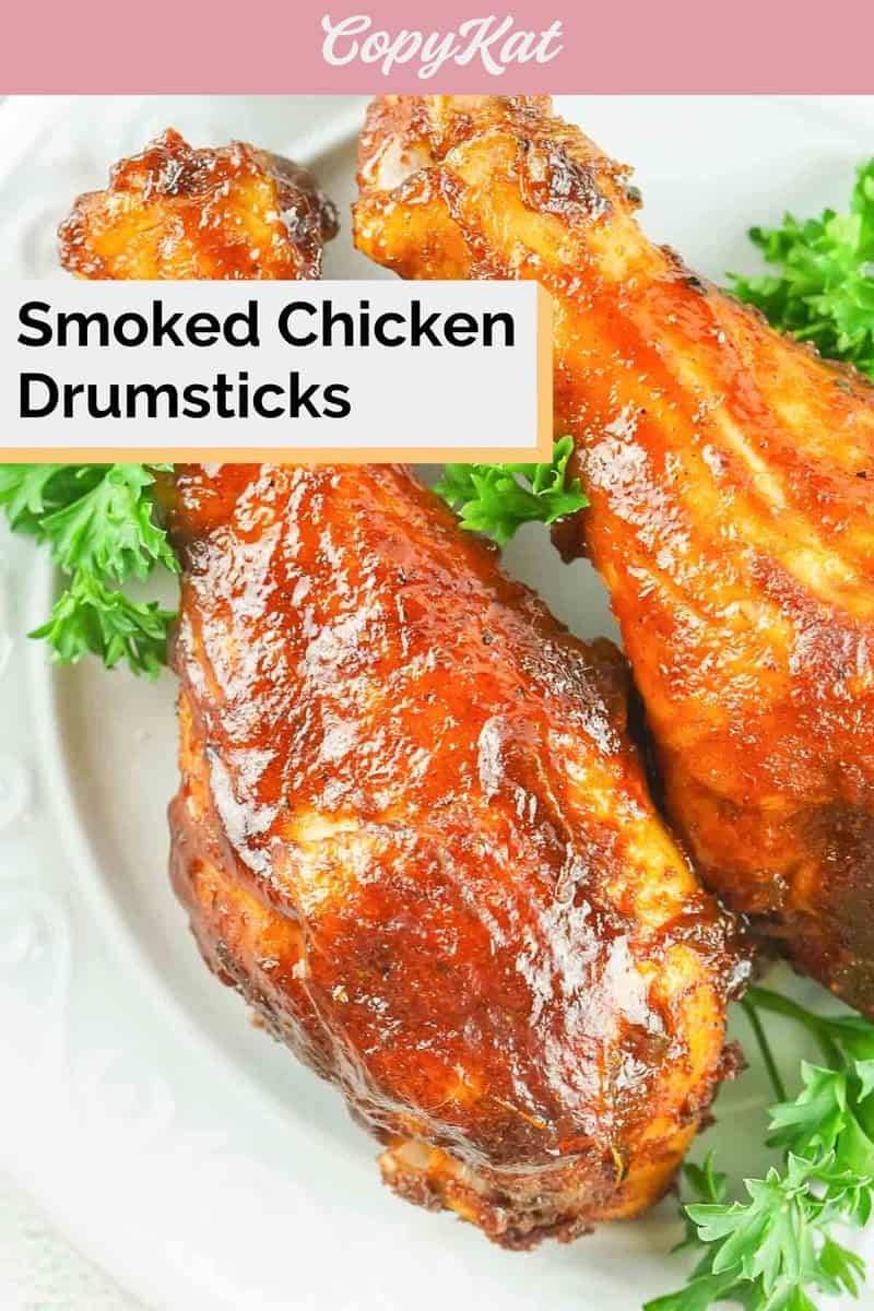 two smoked chicken drumsticks and parsley on a plate.
