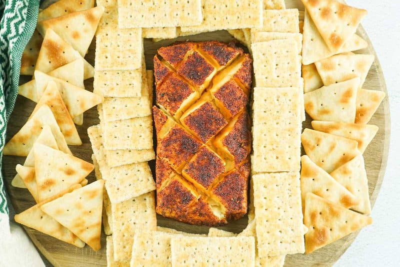 smoked cream cheese with bbq seasoning and crackers on a platter.