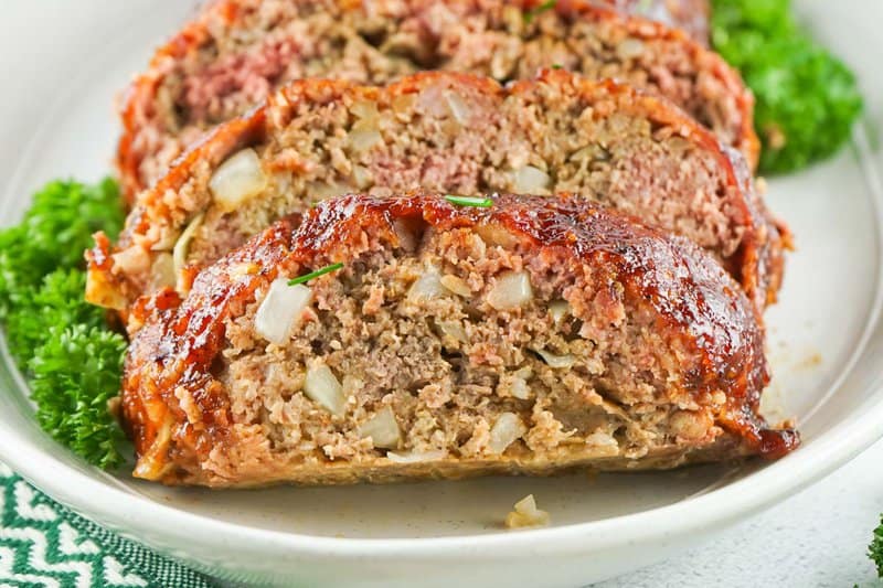 smoked meatloaf slices and parsley on a platter.