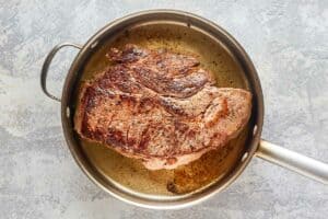 browned beef roast in a pan.