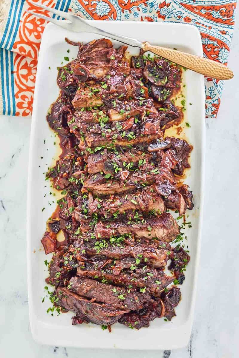 overhead view of stove top pot roast on a white platter.