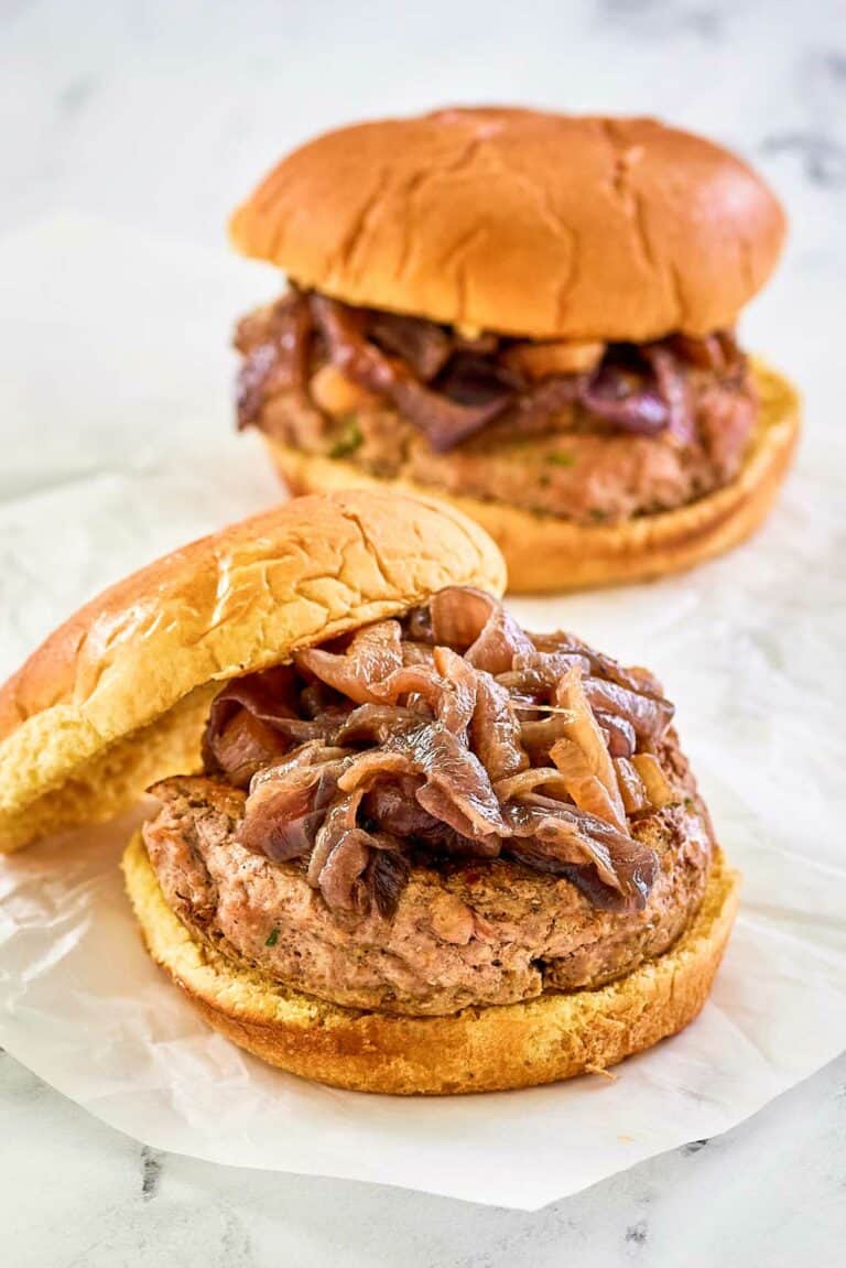 two turkey burgers with caramelized onions and whole grain buns.