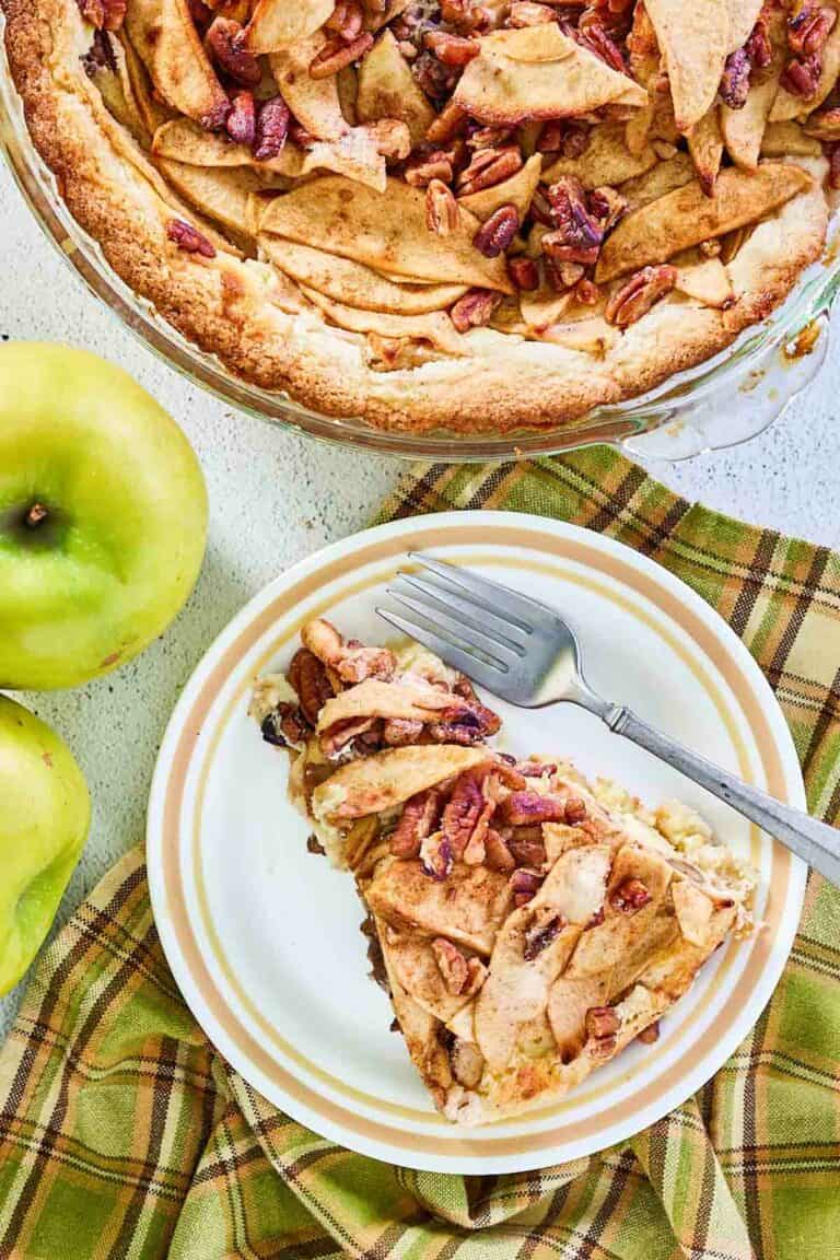 overhead view of apple pie cheesecake and a slice on a plate.