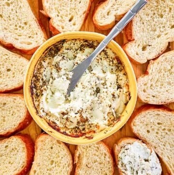 Italian seasoned baked goat cheese and bread slices around it.