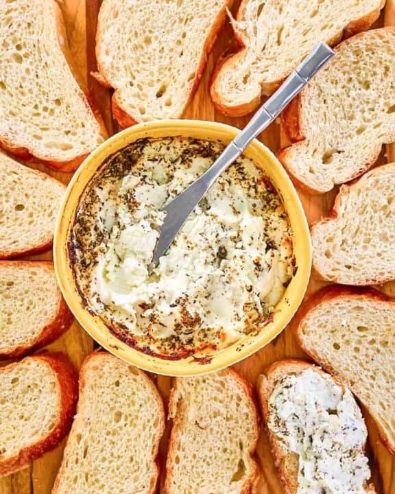 Italian seasoned baked goat cheese and bread slices around it.