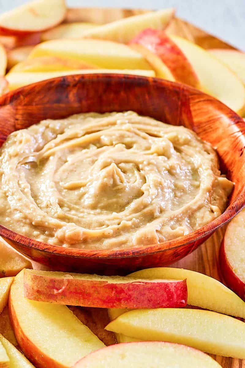 caramel apple dip in a bowl and apple slices around it.