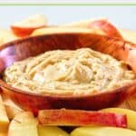 creamy caramel apple dip in a bowl and apple slices next to it.