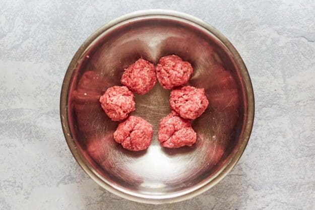 seasoned ground beef divided into portions for hamburgers.
