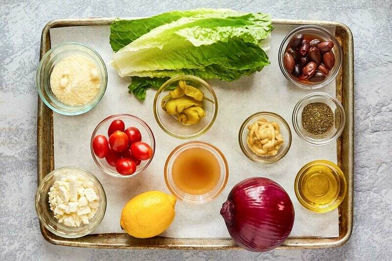 Panera Greek salad and dressing ingredients on a tray.