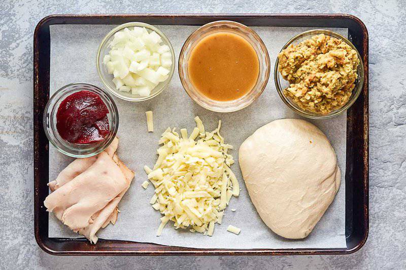 Thanksgiving pizza ingredients on a tray.