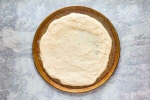 rolled out pizza dough on a pizza pan.