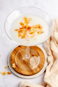 copycat Tommy Bahama coconut cloud martini garnished with toasted coconut flakes.