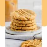 5 peanut butter cookies stacked on a plate.