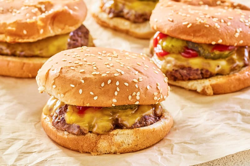 copycat Burger King cheeseburgers on brown parchment paper.