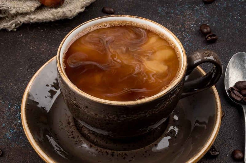 cafe au lait in a coffee cup on a plate.