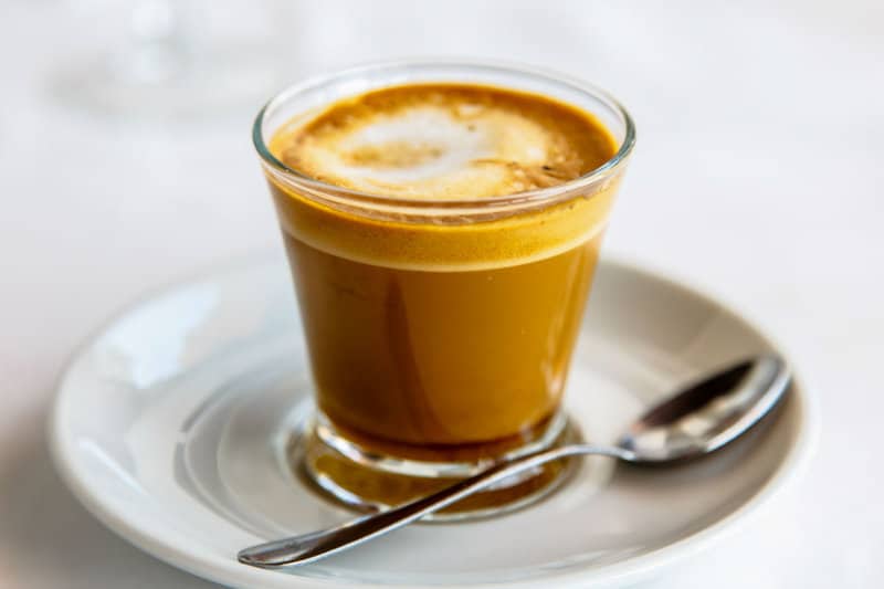 cortado and a spoon on a plate.