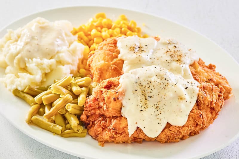 copycat Cracker Barrel Chicken Fried Chicken with sawmill gravy on a plate.