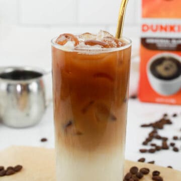 copycat Dunkin Donuts iced caramel macchiato drink with a straw.