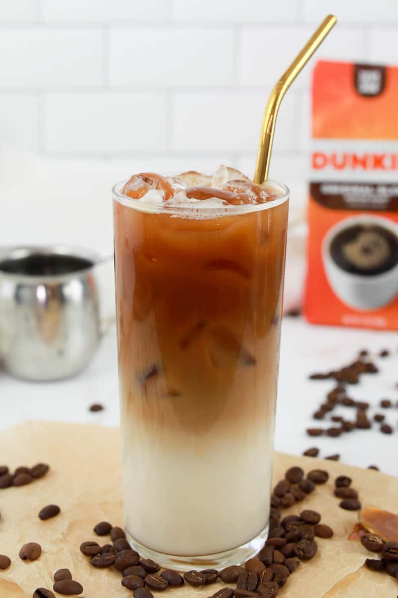 copycat Dunkin Donuts iced caramel macchiato drink with a straw.