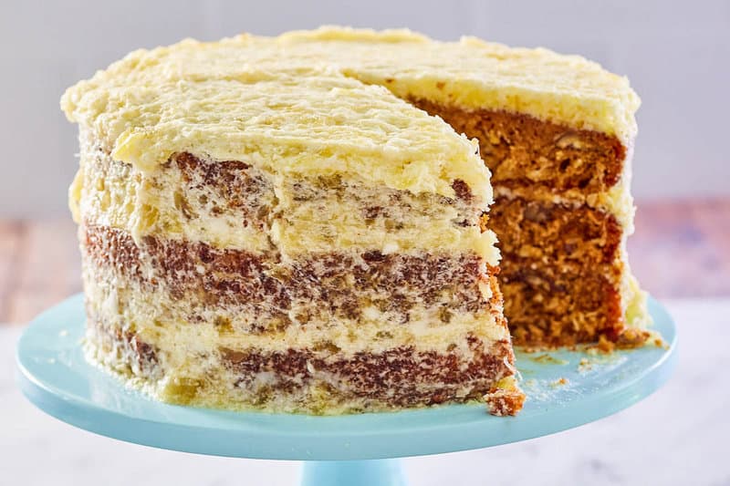 Hawaiian cake with pineapple frosting on a cake stand.