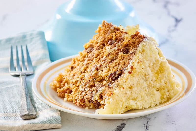 Hawaiian cake slice on a plate and a fork next to it.