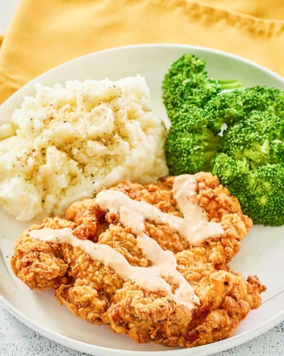 copycat Outback Steakhouse bloomin fried chicken, broccoli, and mashed potatoes on a plate.