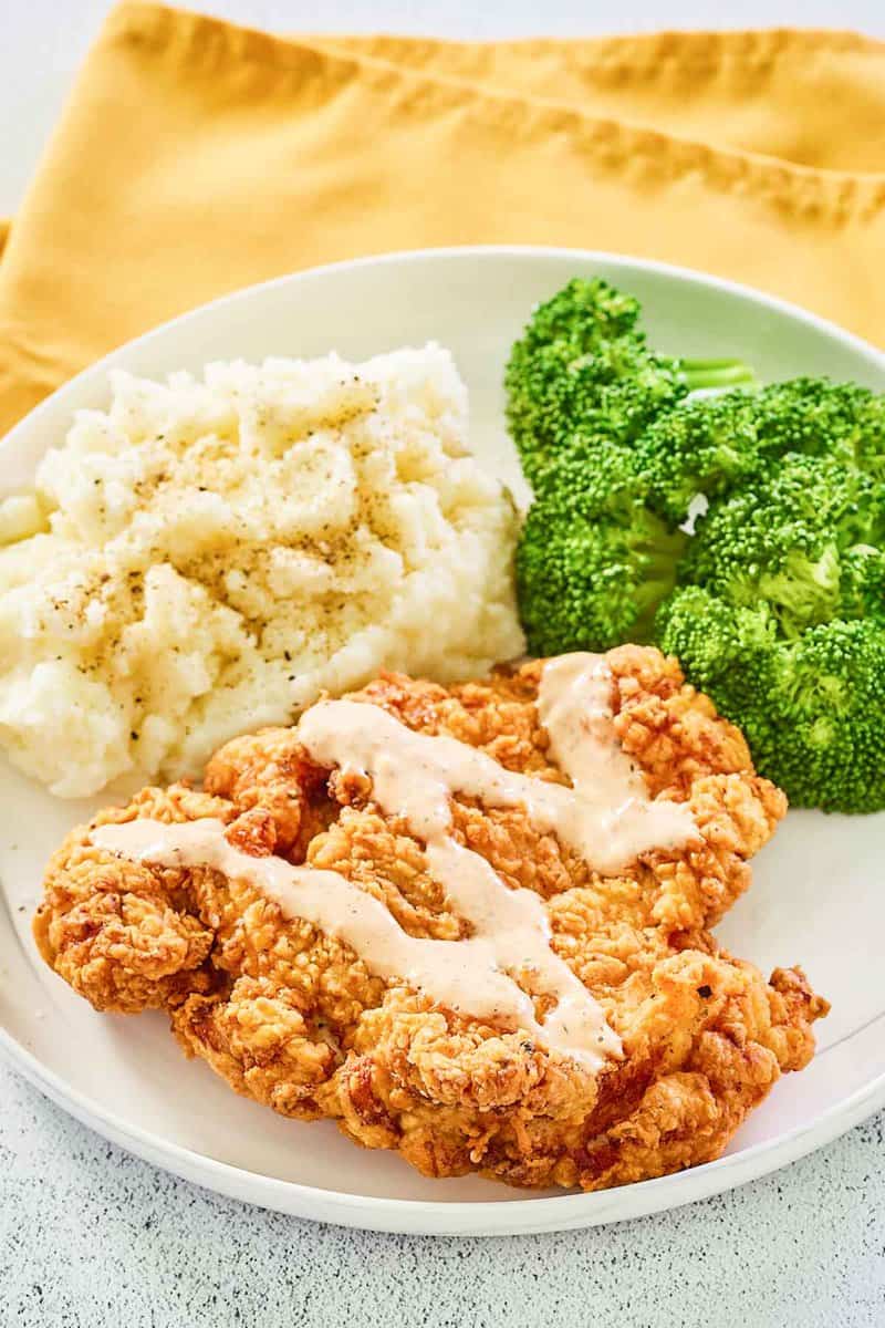 copycat Outback Steakhouse bloomin fried chicken, broccoli, and mashed potatoes on a plate.