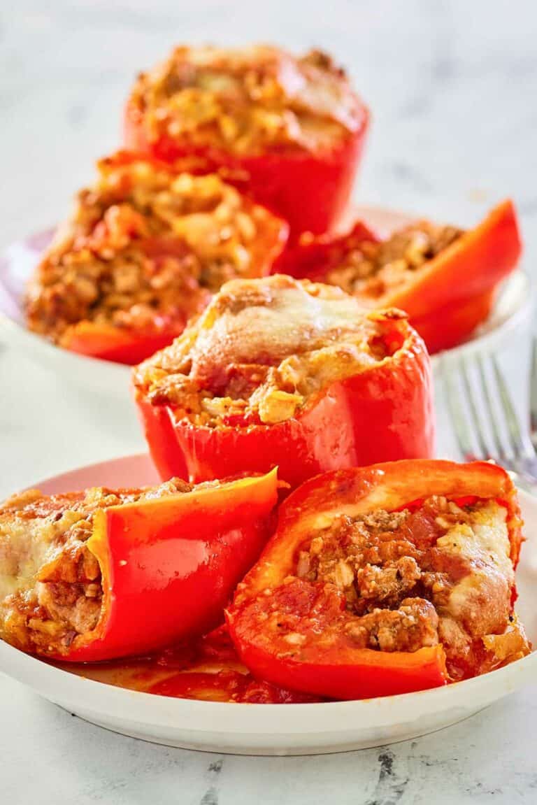 stuffed bell peppers with rice and meat on plates.