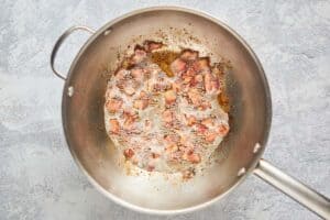 frying bacon pieces in a pan.