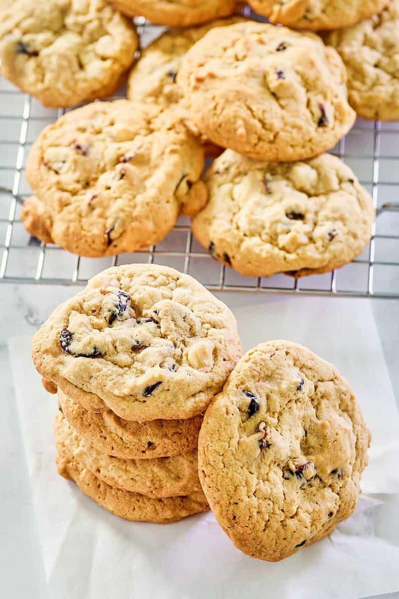 white chocolate cranberry cookies stacked and on a wire rack.