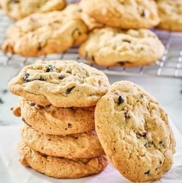 white chocolate cranberry cookies on parchment paper and a wire rack.