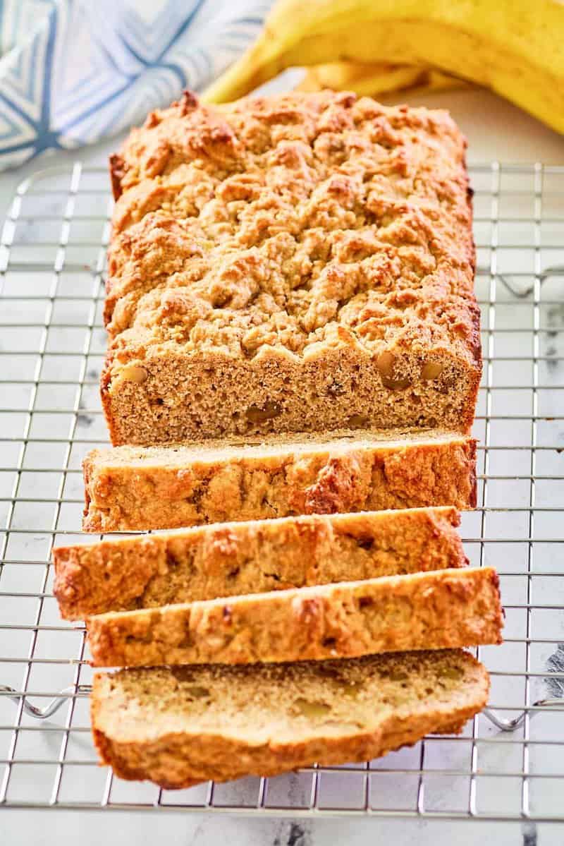 whole wheat banana nut bread slices on a wire rack.