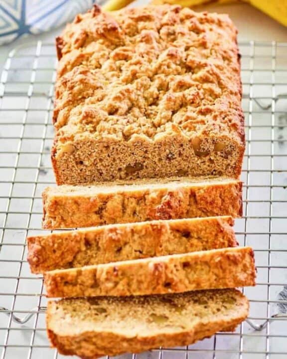 whole wheat banana nut bread slices on a wire rack.