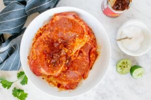 two steaks marinating in adobo and seasonings.