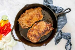 two cooked steaks in a skillet.