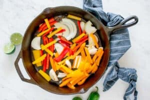 sliced raw vegetables in a skillet.