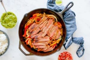 cooked steak strips and veggies in a skillet.