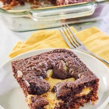 slice of earthquake cake on a plate in front of the cake in a baking dish.