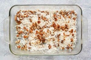 coconut flakes and pecans in a baking dish.