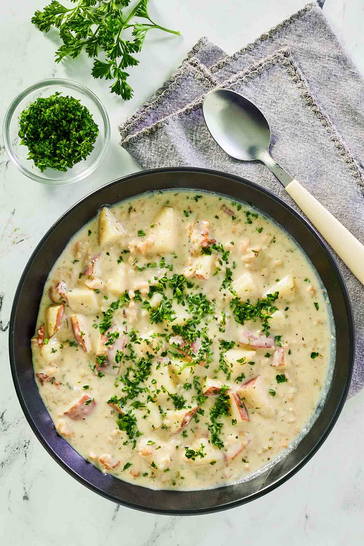 overhead view of clam chowder in a black bowl.