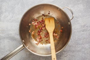 cooked bacon pieces in a skillet.