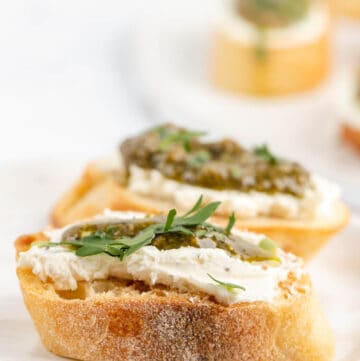 two goat cheese crostini canapes with pesto.