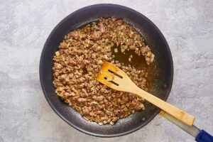 browned ground beef and onions in a skillet.