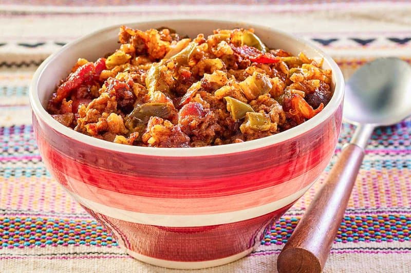 Mexican rice casserole in a bowl and a spoon next to it.